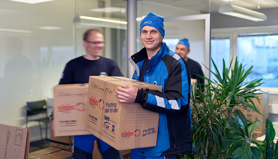 Vinjes ansatte bærer flytteesker og smiler